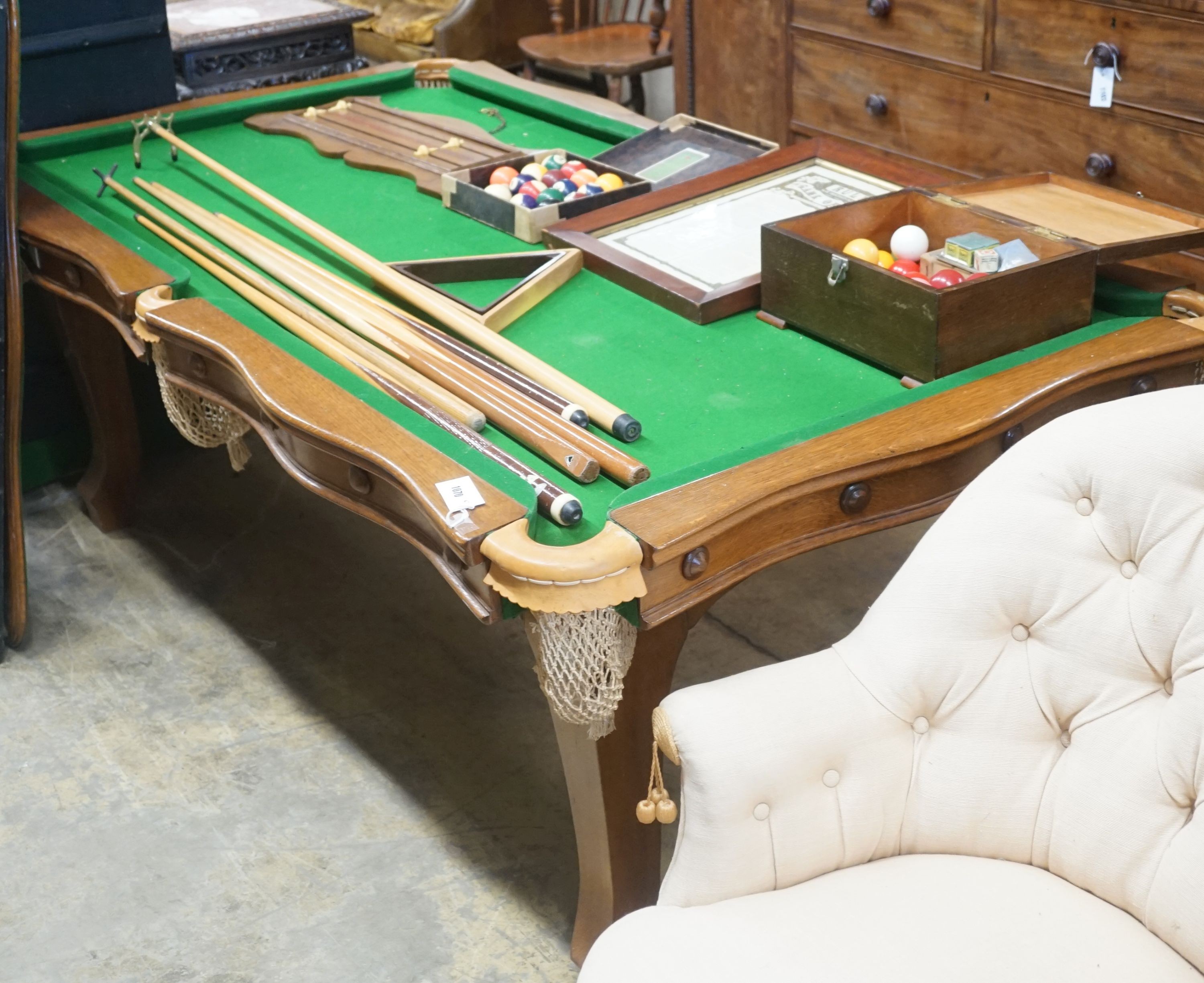 An early 20th century oak snooker / dining table, of rectangular serpentine form, with rise and fall action and full accessories, width 200cm depth 110cm height 74cm